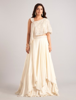 Cream silk lehenga choli highlighted with mirror work