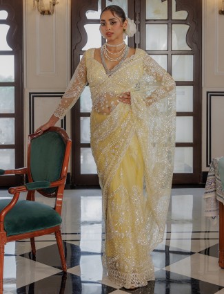 Yellow net saree with rich sequins work
