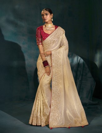 Cream silk bridal style saree teamed with bold maroon blouse